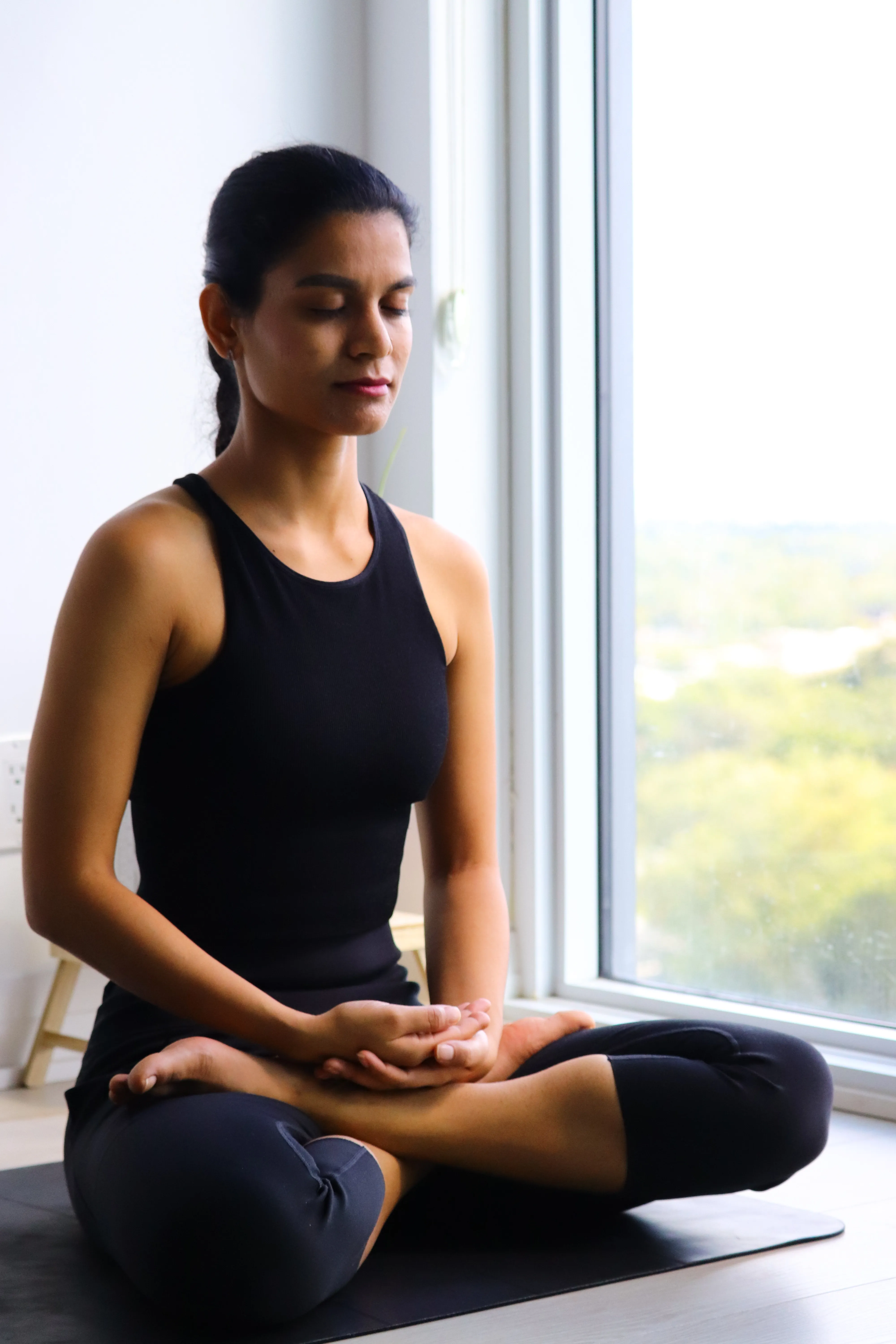 A serene seated posture by a window, bathed in natural light